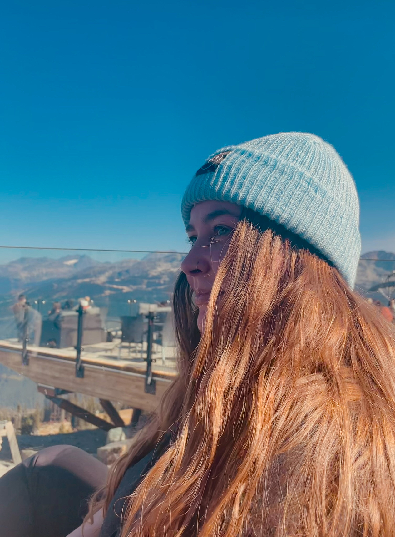 Girl with blue hat looking left at the mountains